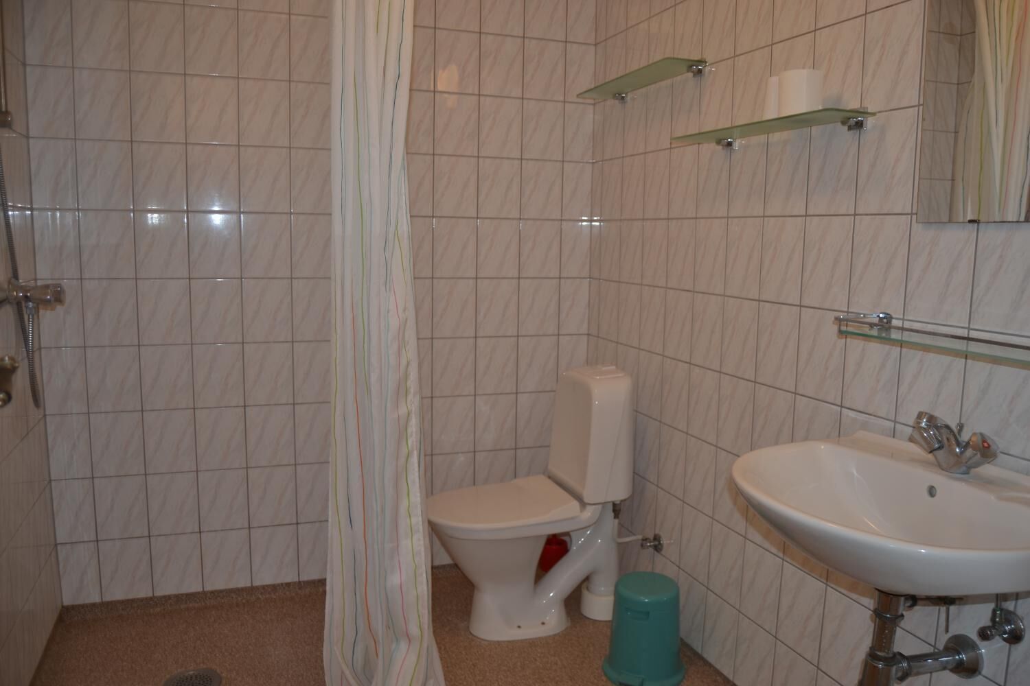 Un baño con inodoro, lavabo y cortina de ducha.