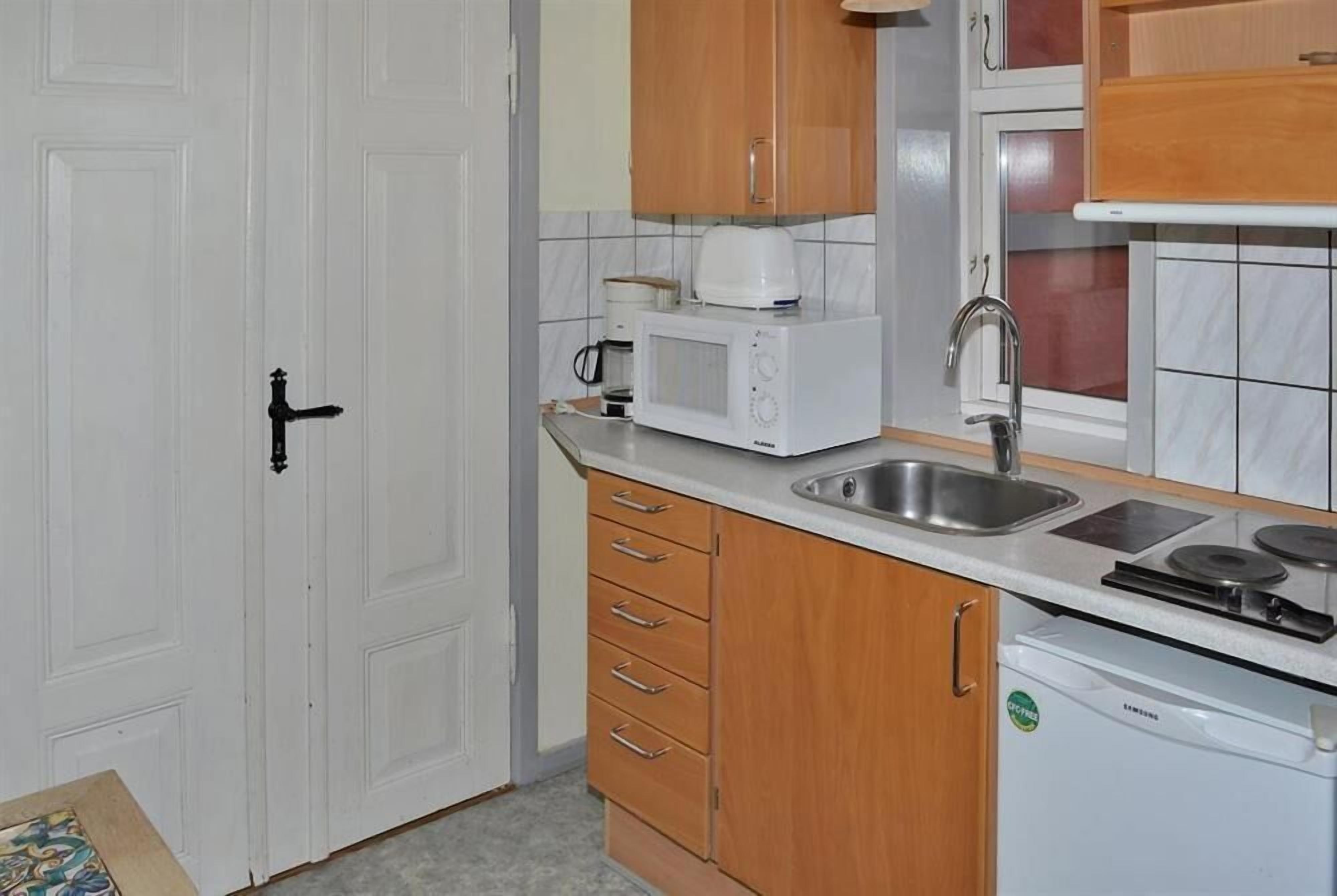 A compact kitchen with a microwave, sink, and a dishwasher.