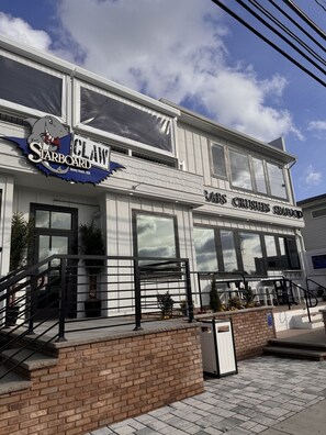 Un bâtiment à deux étages sur lequel on peut lire les inscriptions suivantes : « CLAW Starboard » et « RATS CRUSHES SEAFOOD ».