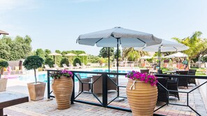 Una piscina al aire libre de temporada, sombrillas