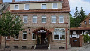 A two-story brick building with a sign reading "Thaler Hof" at the entrance. - Pension Thaler Hof (Thale)