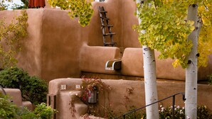 A terraced outdoor area with a wooden ladder, a bench, and a red umbrella. - One Bedroom, Two Bath, Sunset Views & Kiva Fireplaces. Walk Downtown! (Santa Fe)
