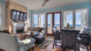 A spacious living room with a fireplace, comfortable seating, and a view of the ocean. - Direct Gulf Front + Private Walk Down Sleeps 12  (Panama City Beach)
