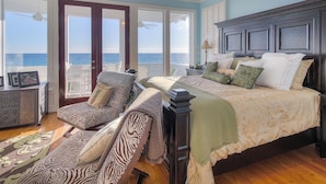 A bedroom with a large bed, a chair, a nightstand, and a view of the ocean. - Direct Gulf Front + Private Walk Down Sleeps 12  (Panama City Beach)