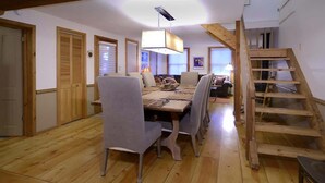 A dining area with a wooden table, chairs, and a staircase. - Maroon Bells (Crested Butte)