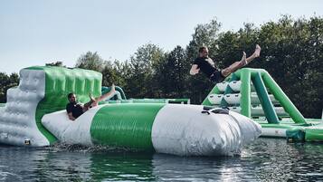 Un homme saute d’une structure gonflable et plonge dans l’eau.