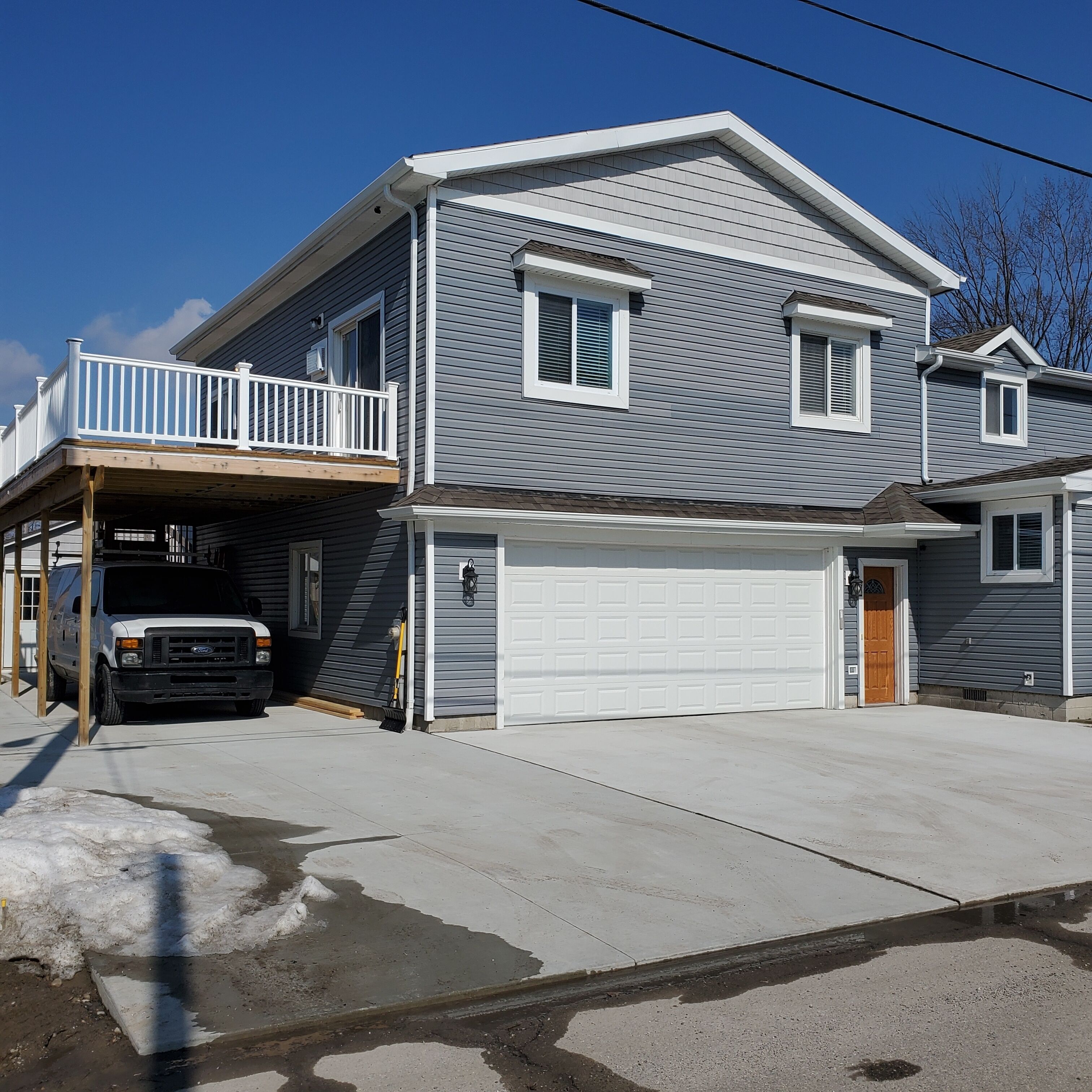 A two-story house with a garage, a covered porch, and a driveway.