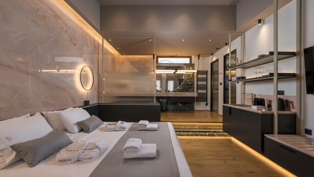 Ein modernes Hotelzimmer mit einem großen Bett, einer Sitzecke und einer Küchenarbeitsplatte.