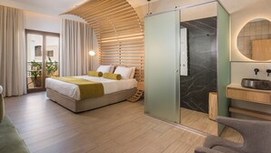Ein modernes Schlafzimmer mit Bett, einer Schiebetür zum Badezimmer und einem Balkon mit Tisch und Stühlen.