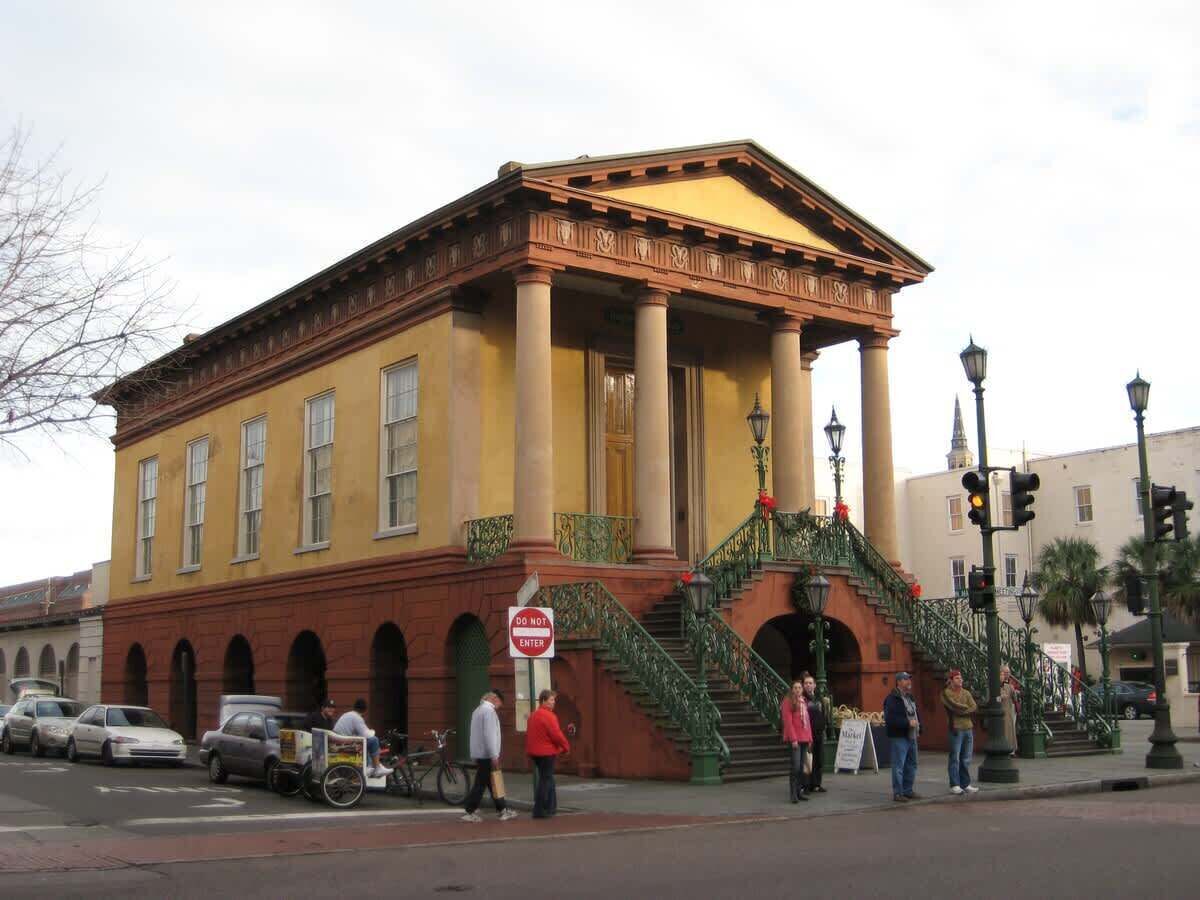 A historic building with a classical facade, columns, and a staircase leading to the entrance.
