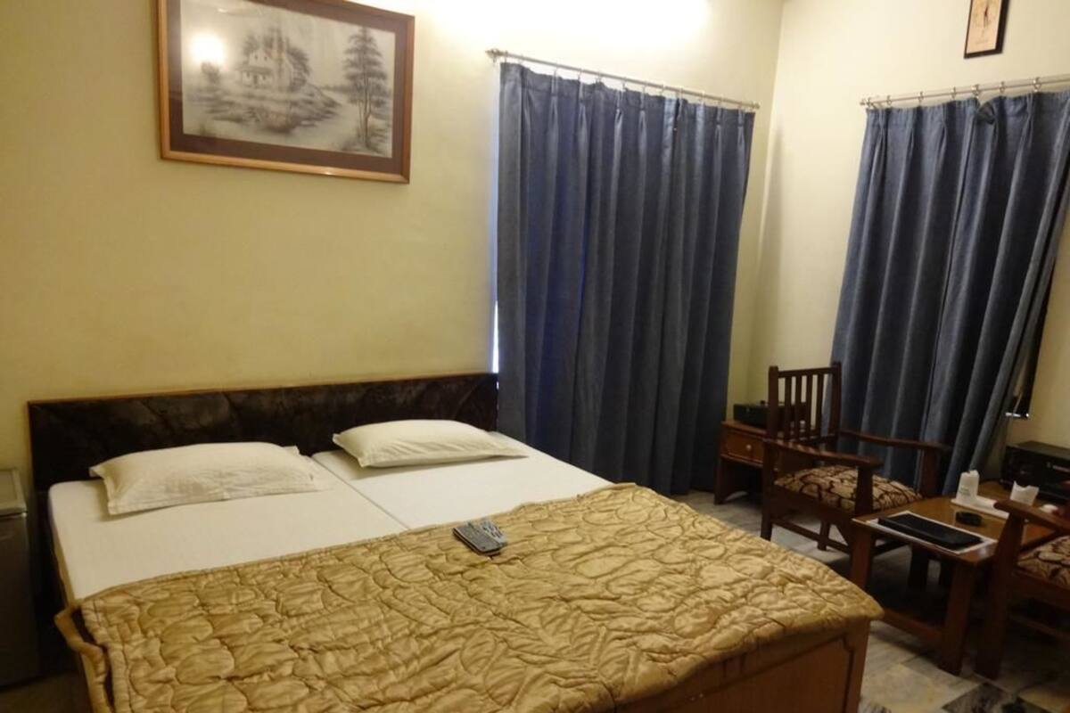 A hotel room with a bed, a desk, and a chair.