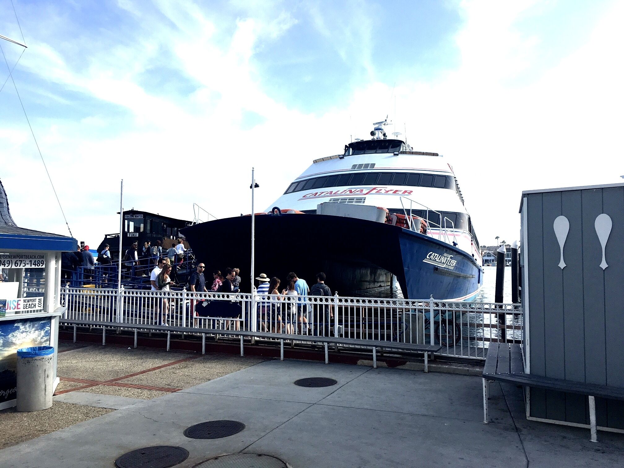 A boat docked at a pier with a crowd of people around it.