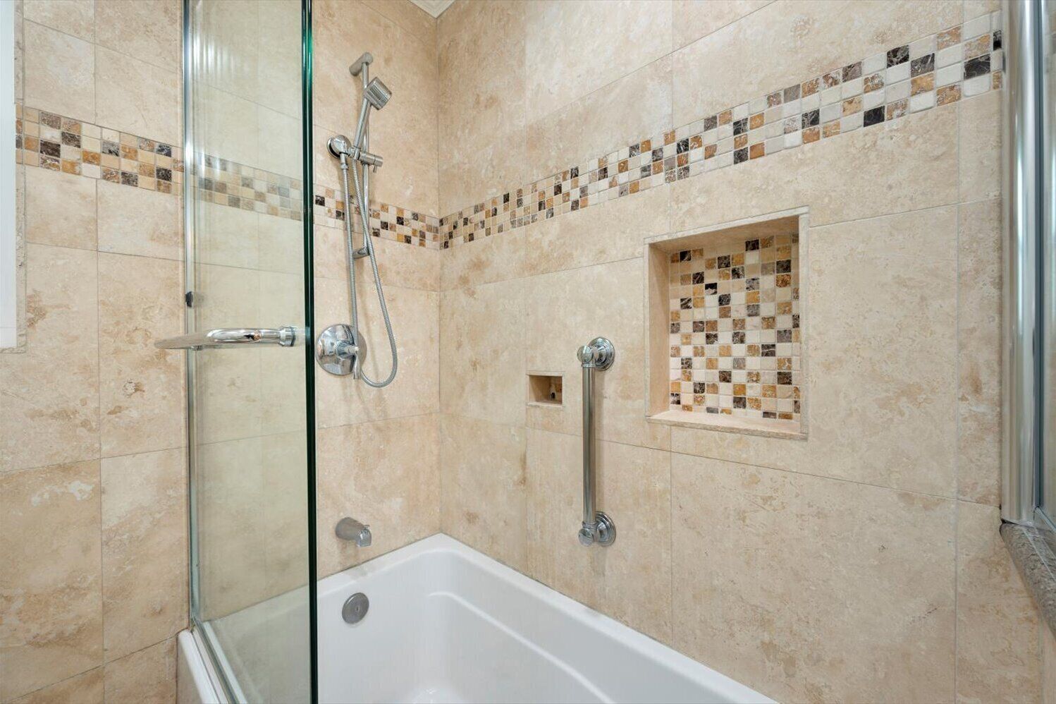 Un baño moderno con ducha envuelta en vidrio, una bañera blanca y zona de ducha con azulejos.