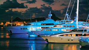 Een jachthaven met verschillende jachten afgemeerd in de nacht.