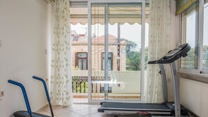 Una habitación con una cinta caminadora, una bicicleta estática y un banco.