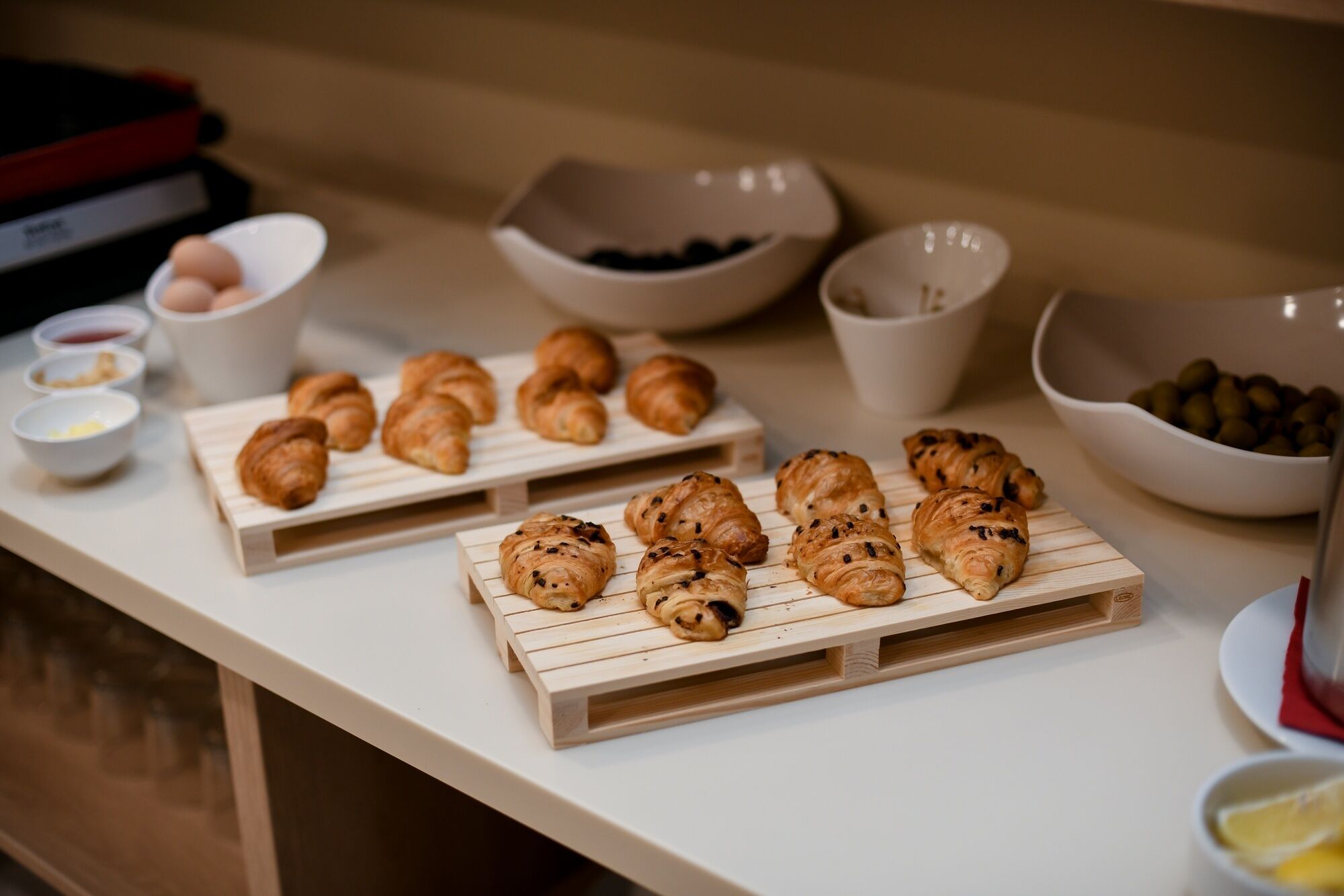 Una mesa con croissants y recipientes pequeños de salsas.