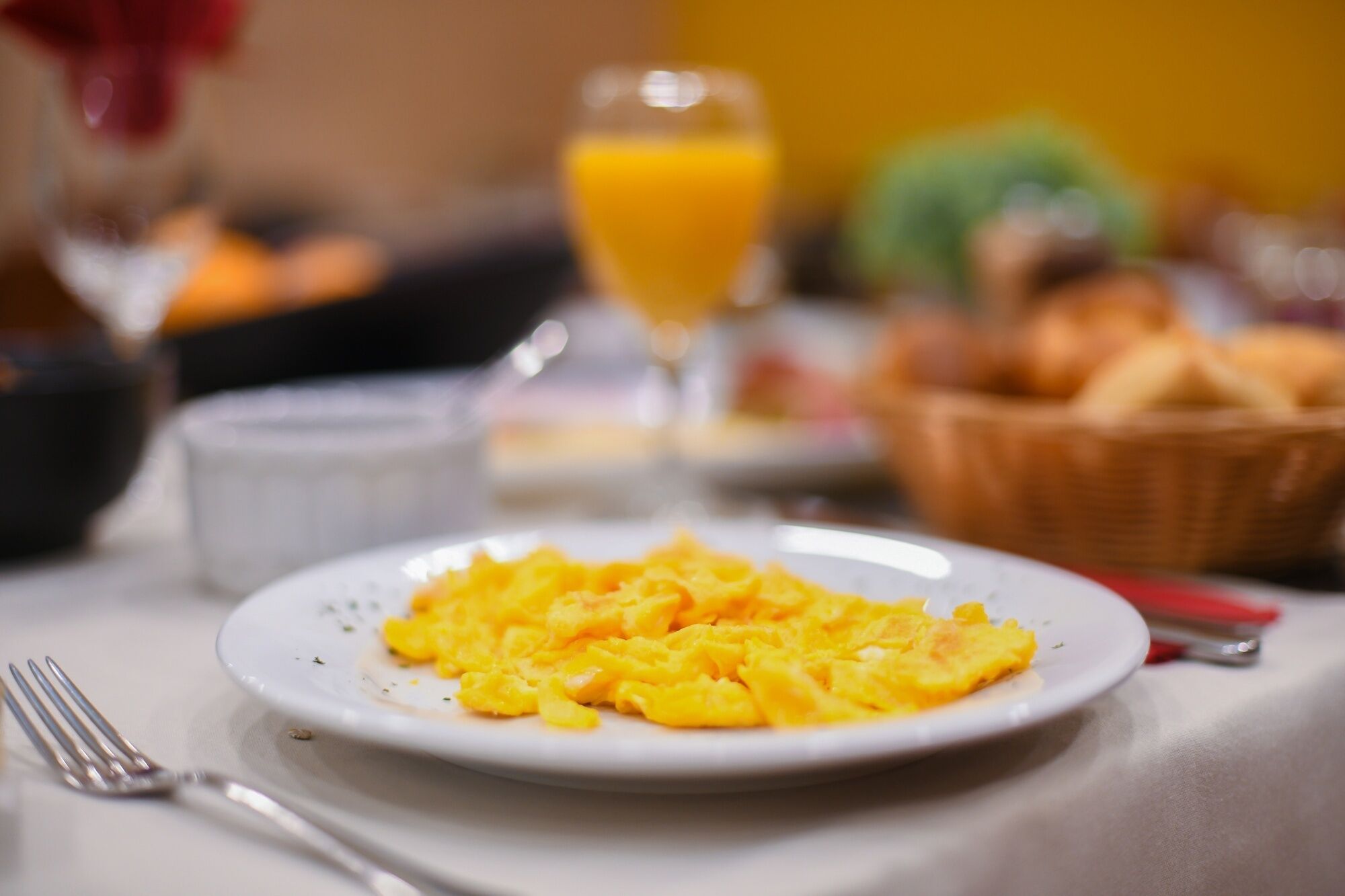 Huevos revueltos en un plato, con un tenedor al lado.
