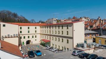 A multi-story building with a parking lot in front.