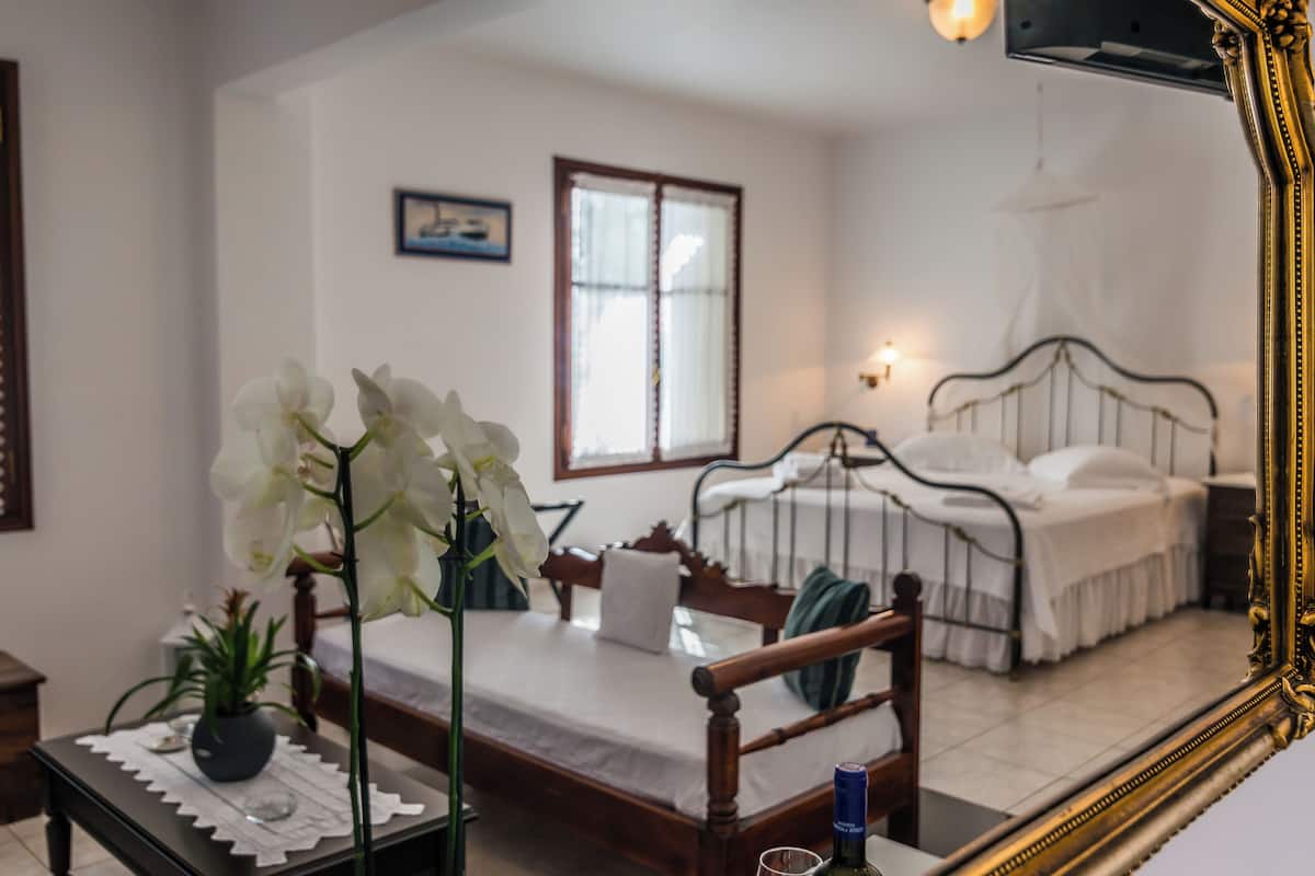 Un dormitorio con cama, mesita de noche y ventana.