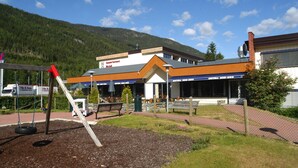 A hotel with a modern design, outdoor seating area, and a view of the surrounding mountains. - Motell Nor-Kro (Nes)