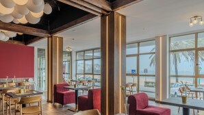 A restaurant with wooden beams, large windows, and red seating. Tables are set with white napkins and gold cups. - Hotel Faranda Rias Altas, Ascend Hotel Collection (Oleiros)