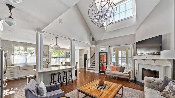 A spacious living area with a fireplace, a dining area, and a kitchen. - Wasser Haus | 4/3 with Private Pool and Hot Tub | Walk to Main (Fredericksburg)