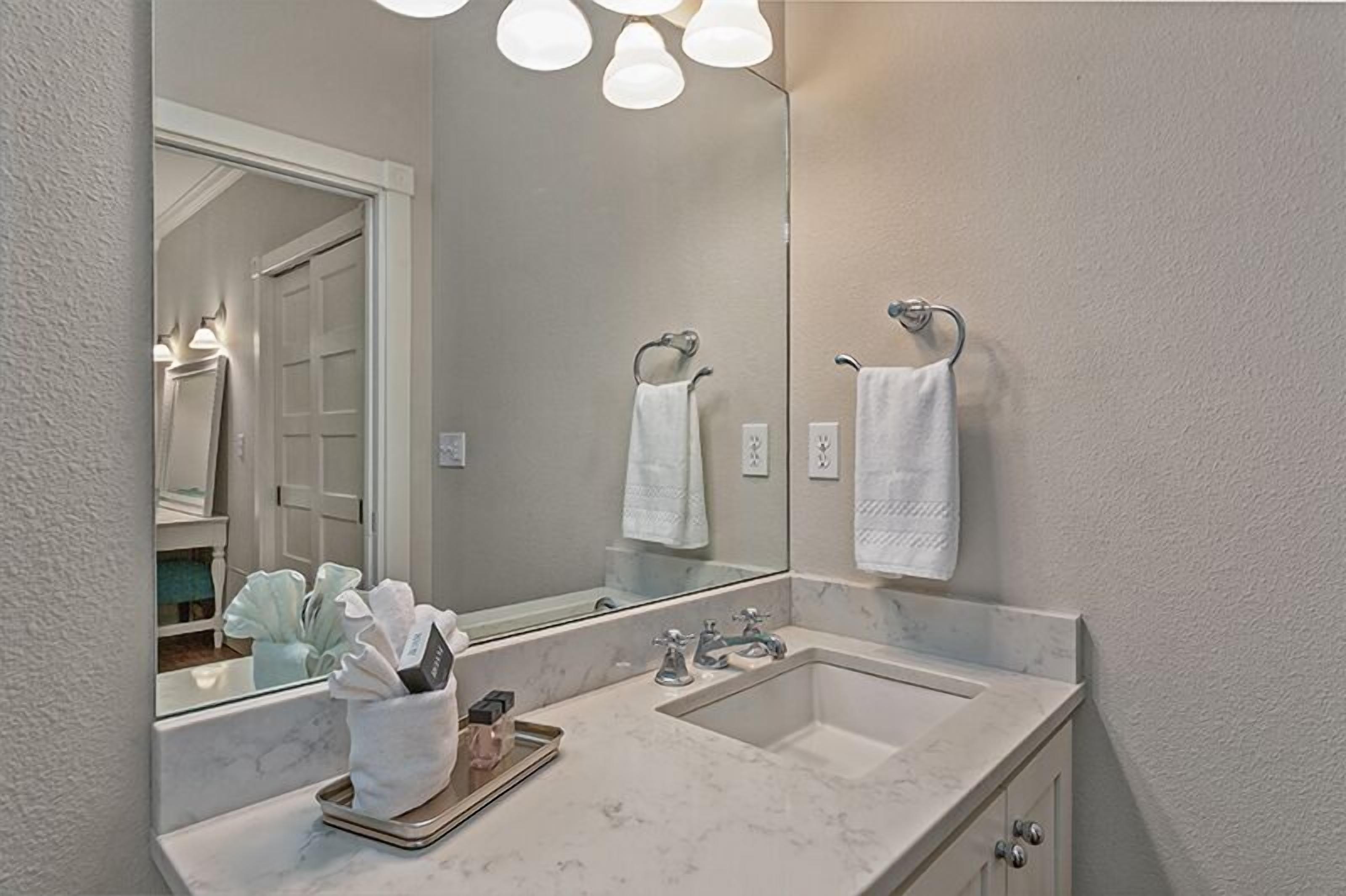 Une salle de bain avec un grand miroir, deux lavabos et un porte-serviettes.