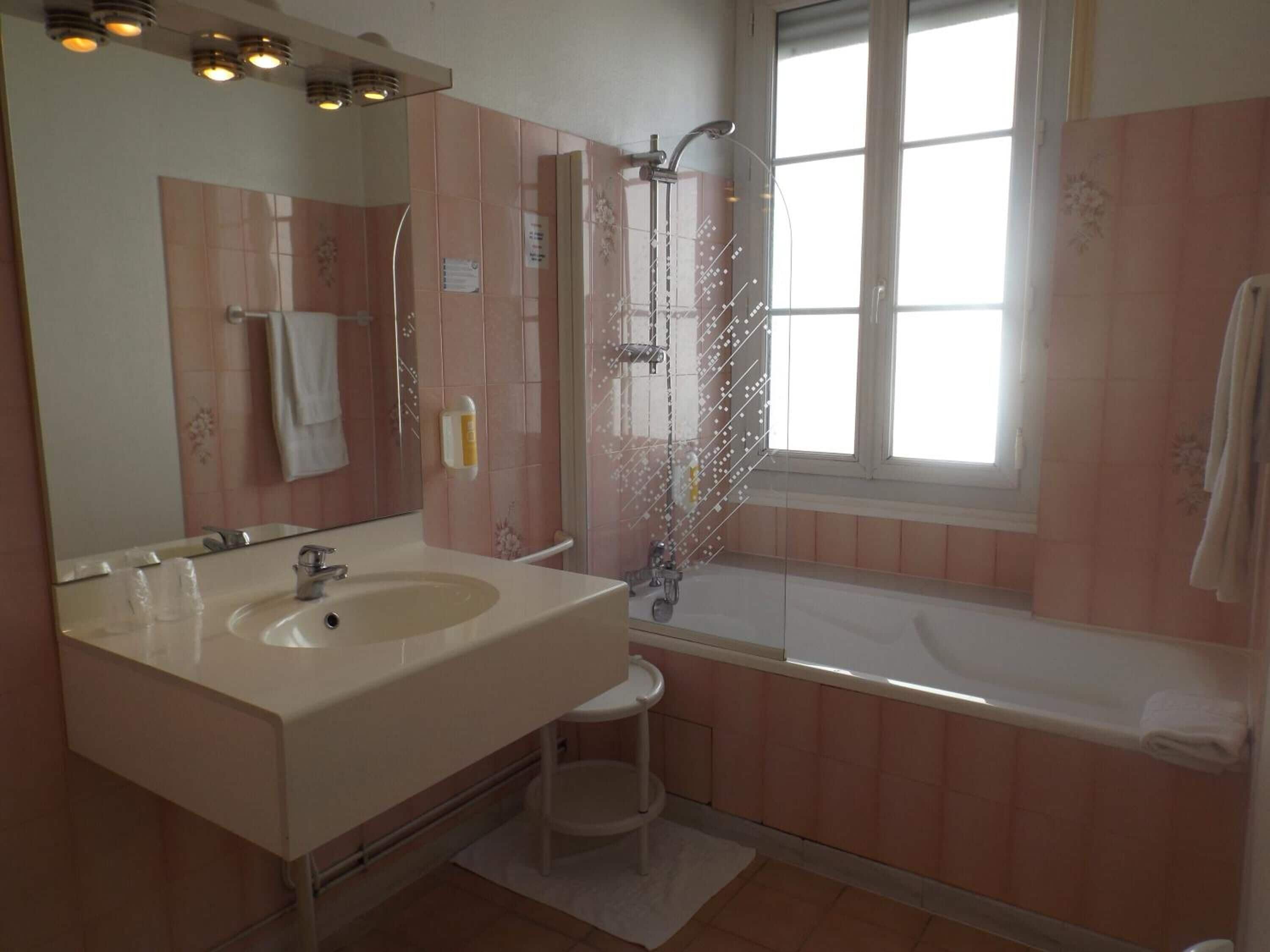 A bathroom with a sink, mirror, shower, and bathtub.