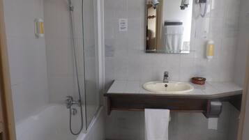 Ein Badezimmer mit Badewanne, Waschbecken, Spiegel und Toilette.