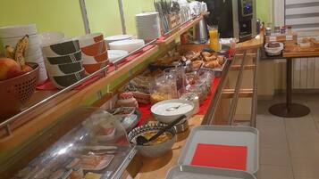 A buffet setup with various food items and utensils.