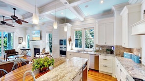 A spacious kitchen with a large island, built-in oven, and a dining area with a view. - Beautiful 6 bedroom home with private pool 2 blocks from beach (Isle of Palms)