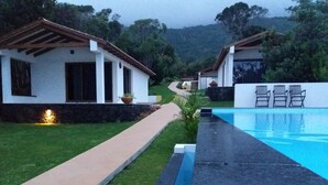 A modern house with a swimming pool, a paved walkway, and a garden area. - Villas Casteletes-bangalow Sea View (Velas)