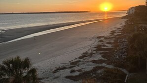 A beach with a sunset, clear sky, and a distant shoreline. - HIGH TIDE Ocean Front Beach Cottage, Best Views on St Simons Island! Pier Area! (Saint Simons Island)