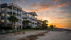 A beachfront hotel with multiple balconies and a view of the ocean at sunset. - HIGH TIDE Ocean Front Beach Cottage, Best Views on St Simons Island! Pier Area! (Saint Simons Island)