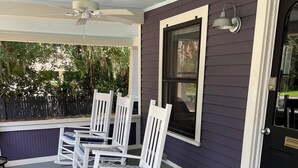 A porch with white rocking chairs and a ceiling fan. - 1887 Royellou House 3BR 2BA (Mt Dora)