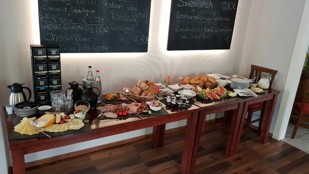 A buffet table with various food items and a selection of beverages. - BASALT Hotel Restaurant Lounge (Hohwacht)