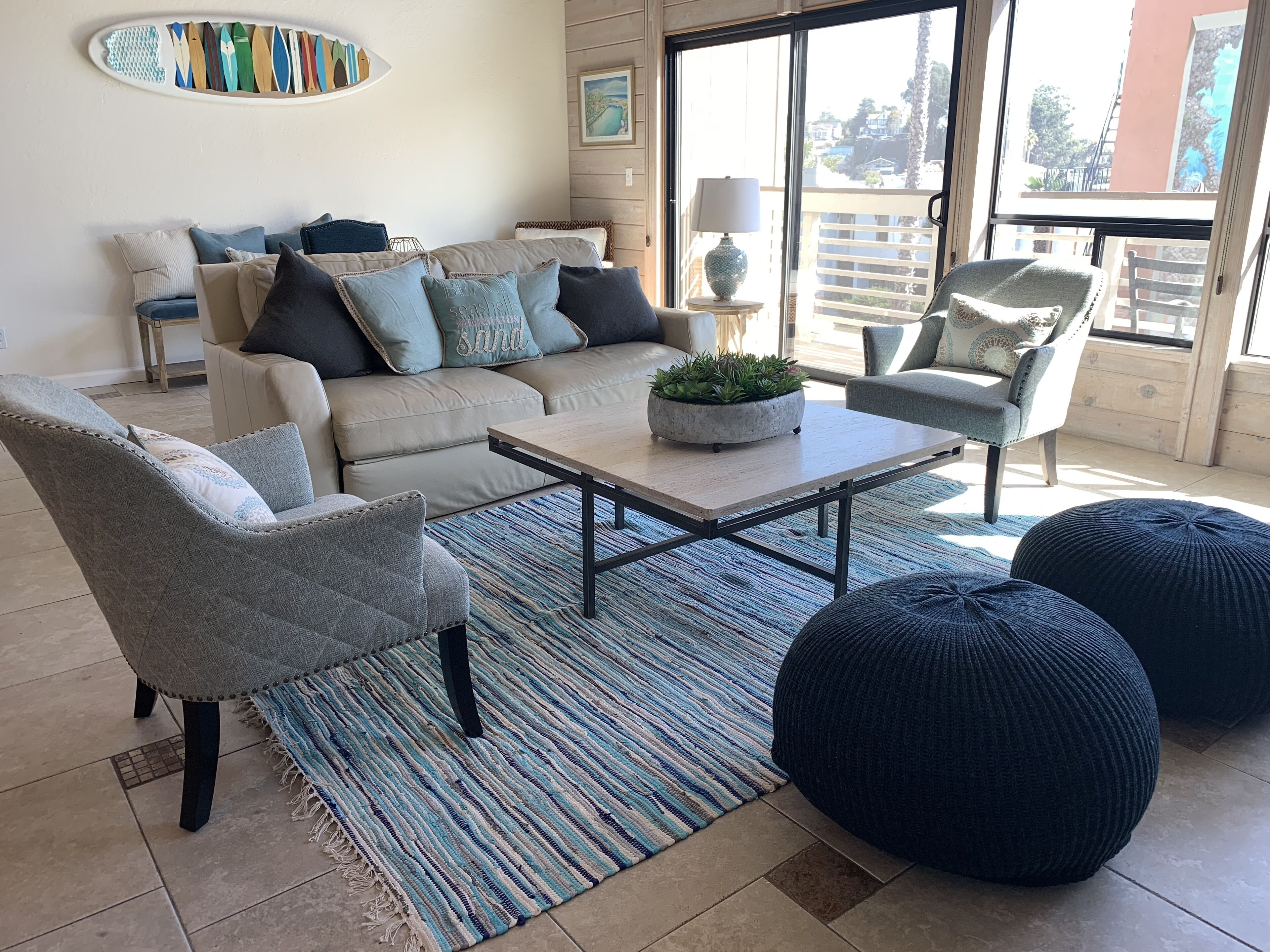 Una sala de estar con un sofá, sillones, una mesa de centro y un ventanal con vistas.