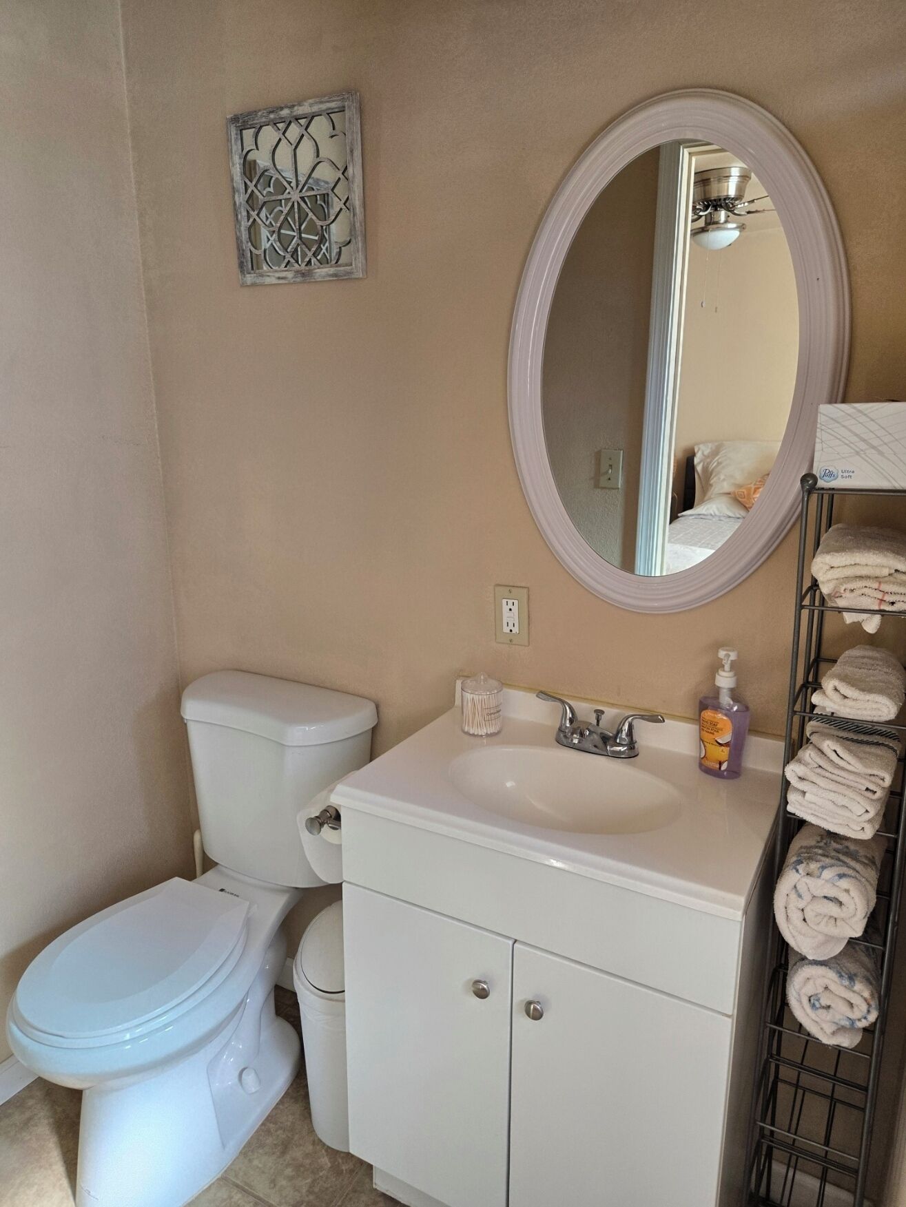 Ein Badezimmer mit Toilette, Waschbecken, Spiegel und Handtuchhalter.