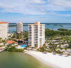 Ein Küstenhotel mit mehreren Hochhäusern, einem Strand und einem Poolbereich.