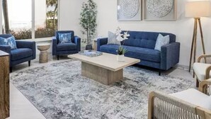A modern living room with a blue sofa, a coffee table, and a floor lamp.