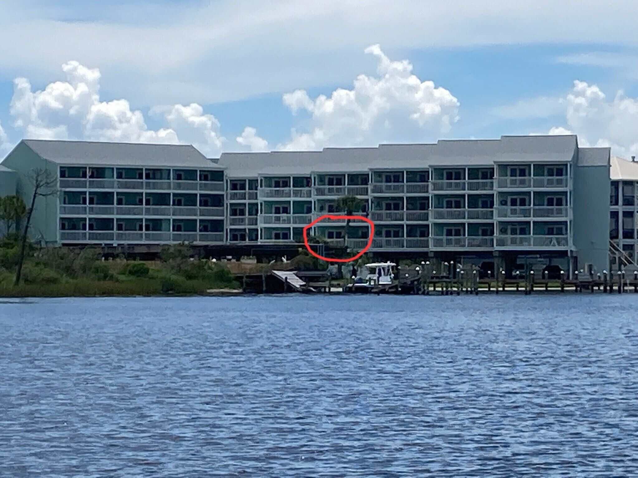 Un grand hôtel à étages, doté de nombreux balcons et situé près d’une étendue d’eau.