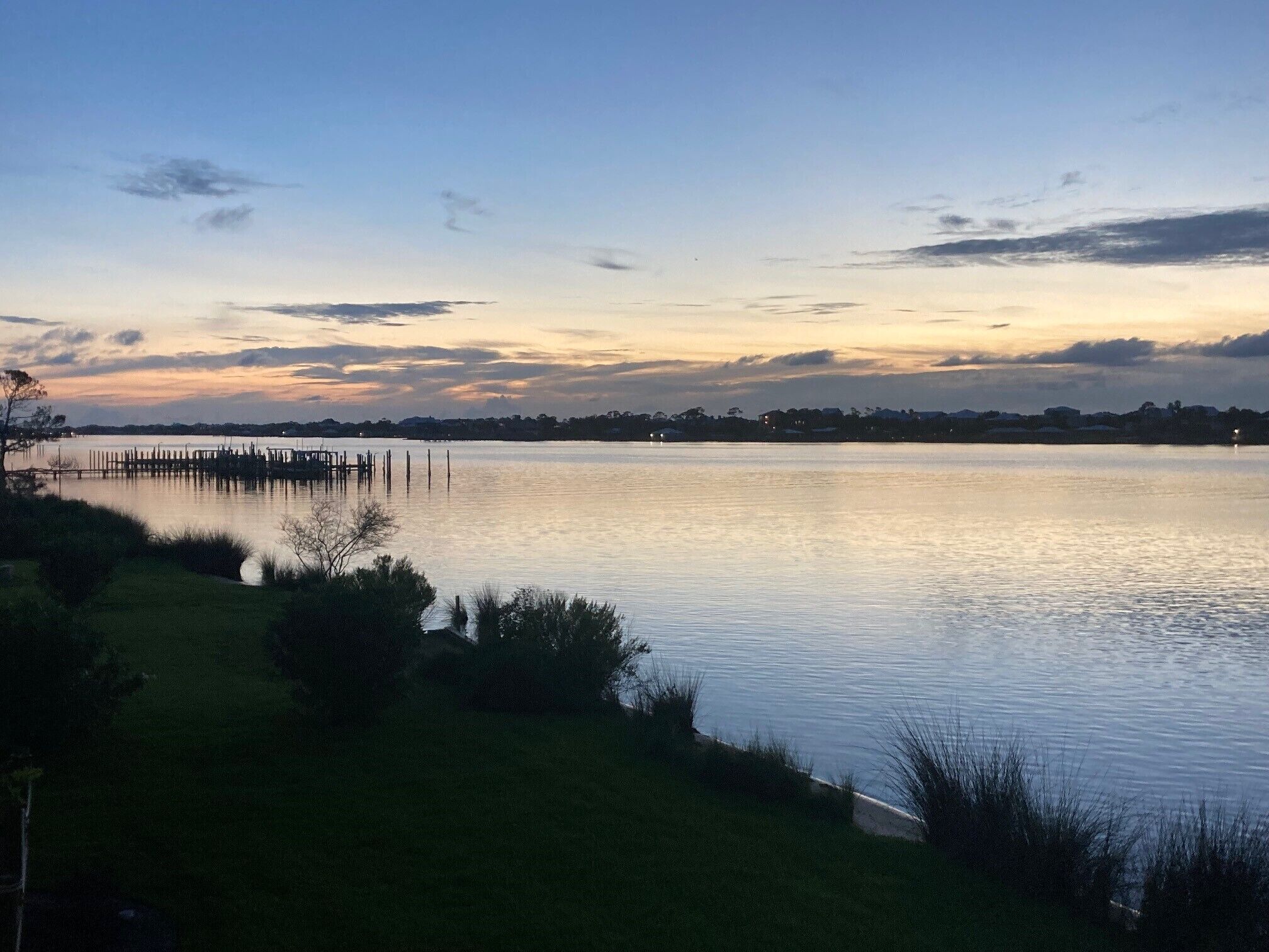 Een rustig meer in de schemering, met een steiger die het water in reikt.