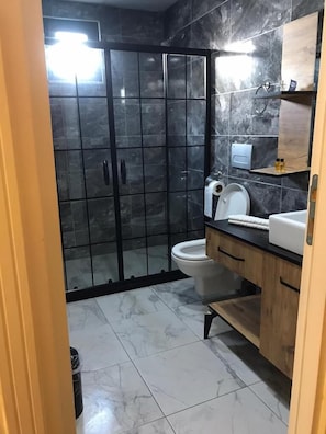 Studio suite | Badkamer | Een douche, gratis toiletartikelen, een haardroger, pantoffels