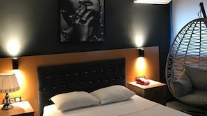 A hotel room with a bed, two bedside tables with lamps, a hanging chair, and a wall-mounted air conditioner. - Samsun Osmanli Otel (Samsun)
