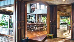 Un interior de madera espacioso con comedor, cocina y vistas al exterior.