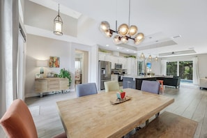 A spacious kitchen with modern appliances, a dining area with a wooden table, and a large island with seating.