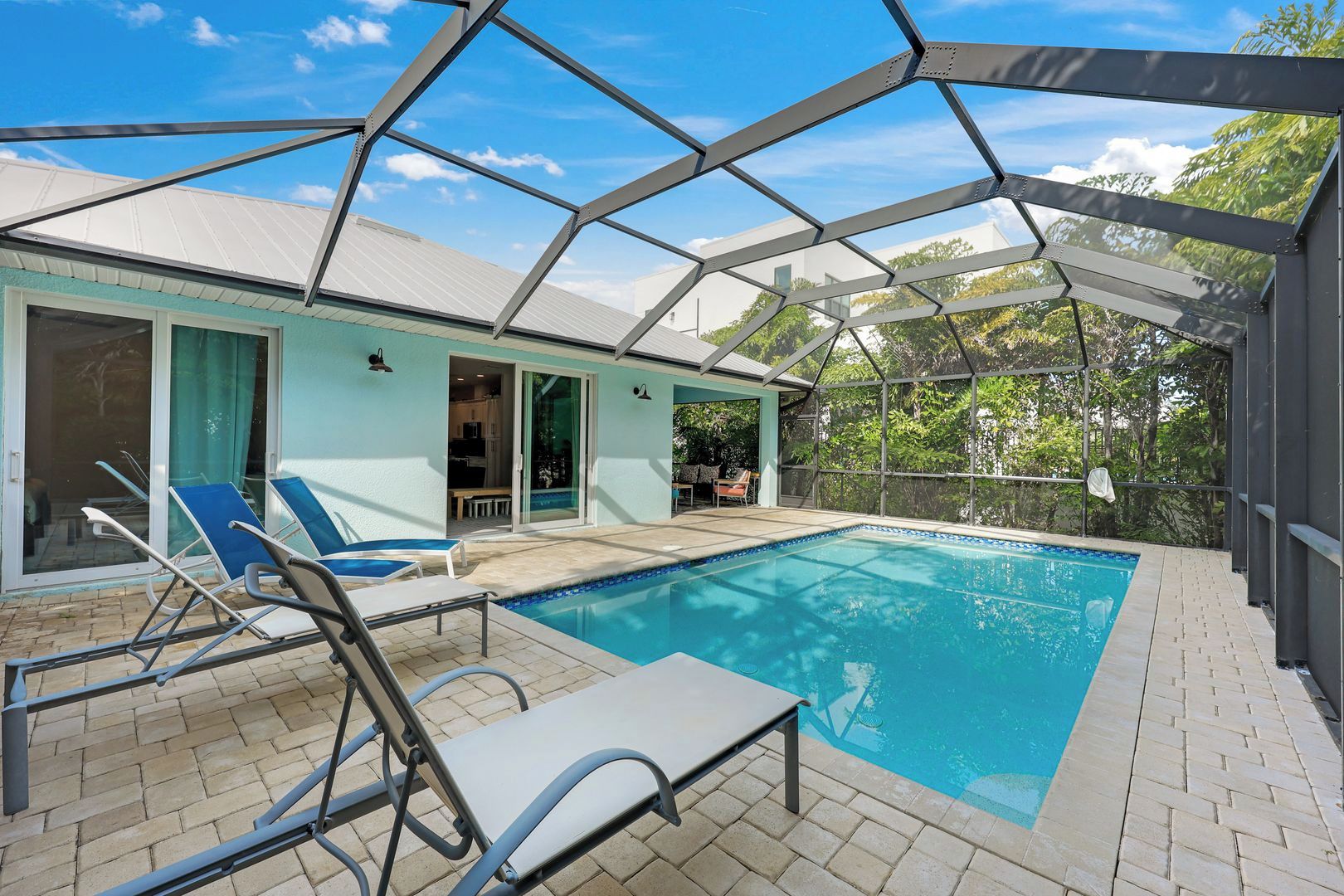 Una piscina coperta esterna con lettini e un'area patio.