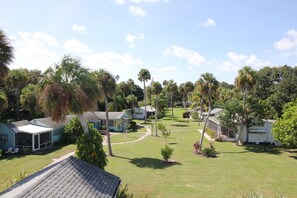 A residential area with multiple houses, each with a distinct architectural style, surrounded by lush greenery and palm trees.