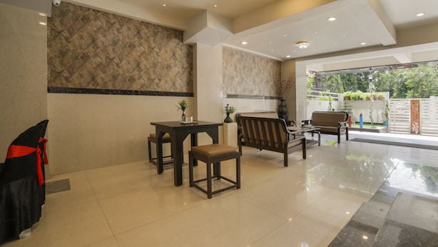 A clean, modern lobby with a seating area, a reception desk, and a view of the outdoors. - Itsy Hotels Le Clover (Nagpur)