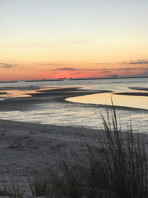 Une plage aux eaux calmes, avec un coucher de soleil.